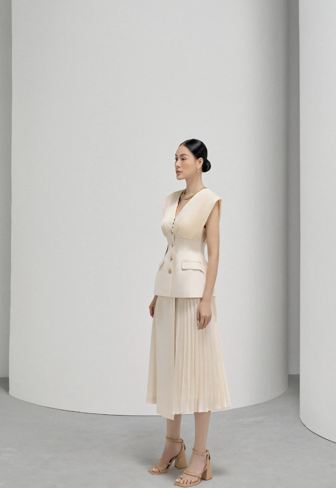 Elegant Beige Sleeveless Dress with Pleated Design and Gold Buttons